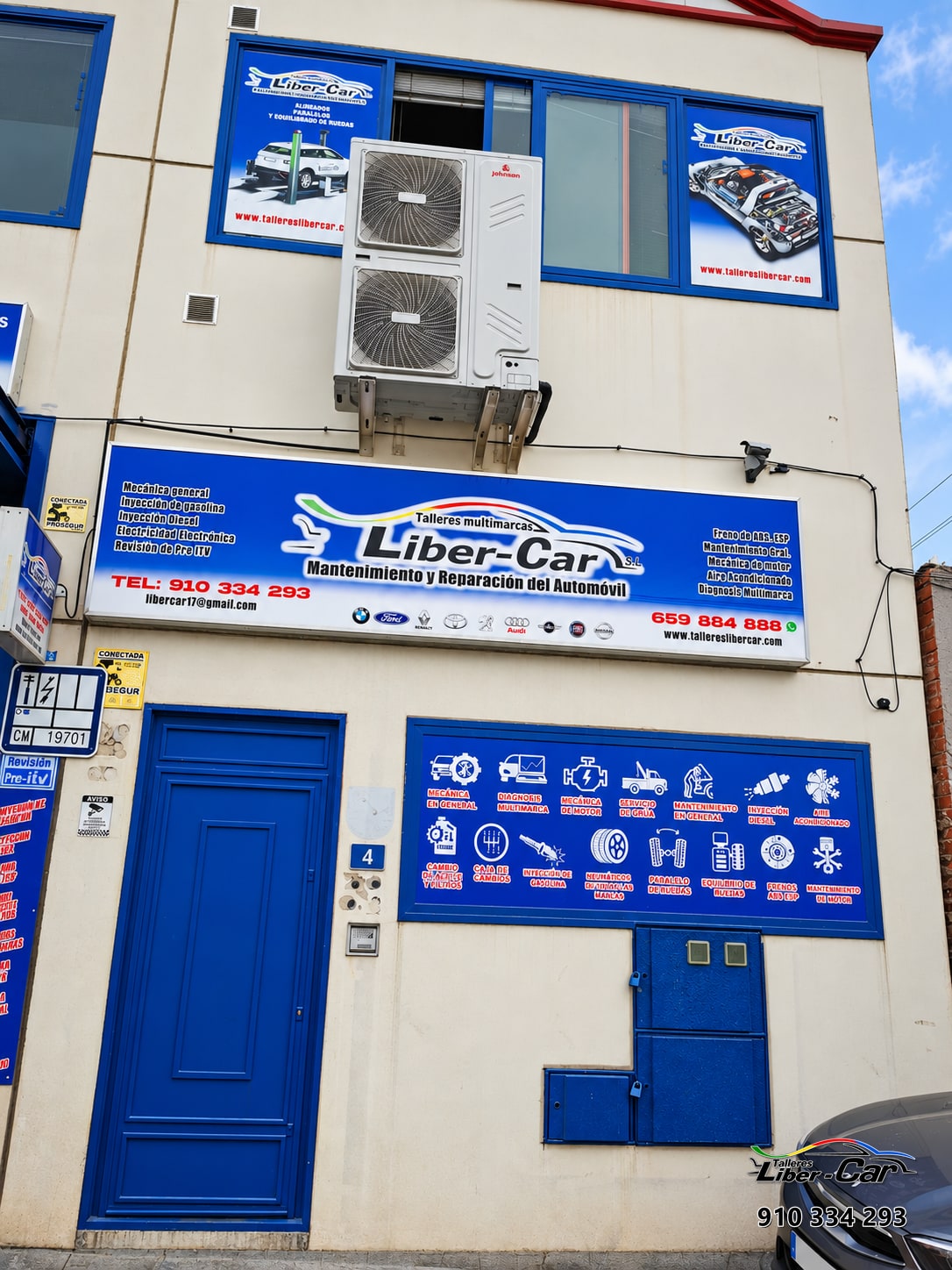 Fachada de Liber-Car con rótulo del taller y unidad de climatización